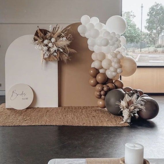 Elegant fotohörna för en festlig babyshower med ballonger och torkade blommor.